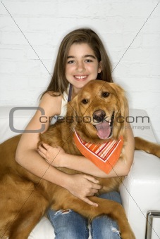 Female adolescent  holding dog.