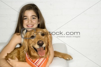 Female adolescent holding dog.