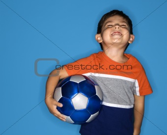 Male boy holding soccer ball.