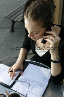 Young woman doing paperwork at cafe