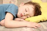 The boy sleeps sound sleep on a yellow pillow