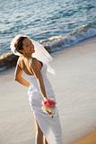 Bride standing on beach.