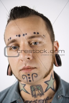 Adult male with tattoos and piercings.