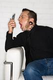 Adult male yelling into cellphone.