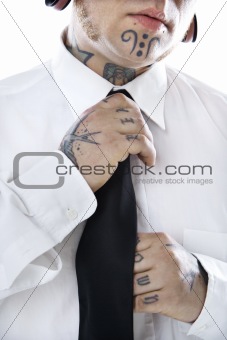 Adult male adjusting necktie.