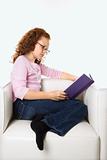 Girl sitting reading book.