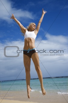 Woman jumping on beach.