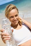 Woman holding jump rope and water bottle.