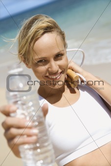 Woman holding jump rope and water bottle.