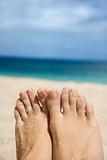Woman's sandy feet on beach.