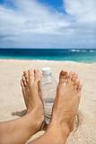 Woman's sandy feet on beach.