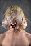 Male teen screaming with long hair in front of face.