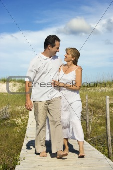Couple holding each other walking down path.