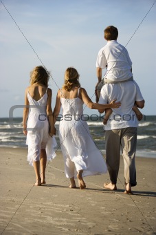 Family walking down beach.