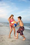 Boy and girl pulling on beachball.