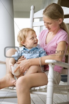 Girl holding boy toddler.