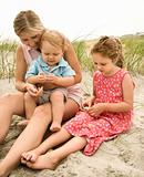Mom, daughter and son looking at shells.