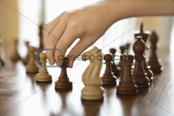 Hand moving chess piece.