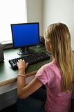 Pre-teen girl working at computer. 
