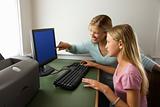 Teenage girl and mom working on computer together.