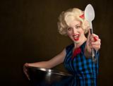 Pretty retro blonde woman in vintage 50s dress with bowl and spoon