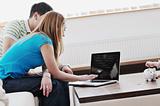 young couple working on laptop at home