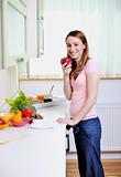 happy young  woman with apple in kitchen