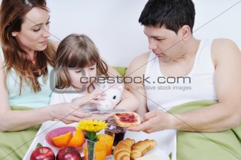 happy young family eat breakfast in bed