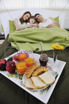 happy young family eat breakfast in bed