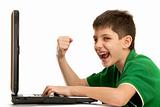 Emotional kid is playing computer game on the laptop