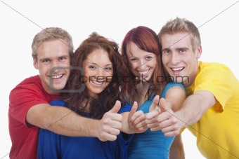 portrait of a group of four happy young people showing thumbs up sign