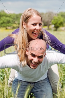 Happy cute woman being piggy backed by her boyfriend