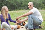 Couple sitting in blanket smiling with picnic mode