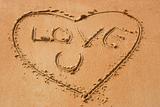 Love you handwritten on sandy beach