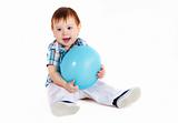 Child sitting with blue baloon