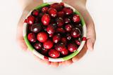 shot of child holding a bowl of fresh cranberries