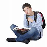 Young contemplative male student sitting on floor with book