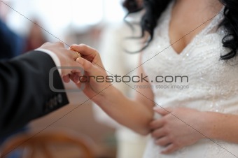 Bride putting the ring on groom's finger