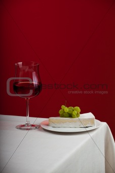 glass of red wine and camembert cheese with grapes