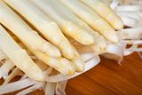 raw white asparagus on a wooden blank