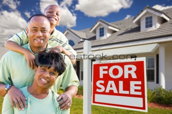 Happy and Attractive African American Family with For Sale Real Estate Sign and House.