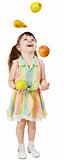 Little funny girl juggles fruit