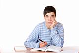 Young handsome male student sitting on desk learning for exam