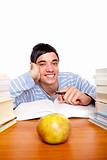 Young smiling male student sitting happy between study books