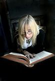 Portrait of the beautiful blonde woman with glasses and old book
