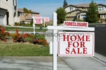 Row of Foreclosure Home For Sale Real Estate Signs in Front of Houses.
