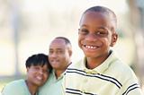 Handsome African American Boy with Proud Parents Standing By in the Park.
