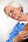 Elder woman playing guitar.