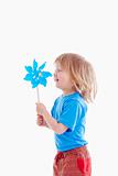 studio shot of a boy playing with pinwheel - isolated on white