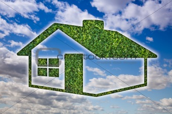 Green Grass House Icon Over Blue Sky and Clouds.
